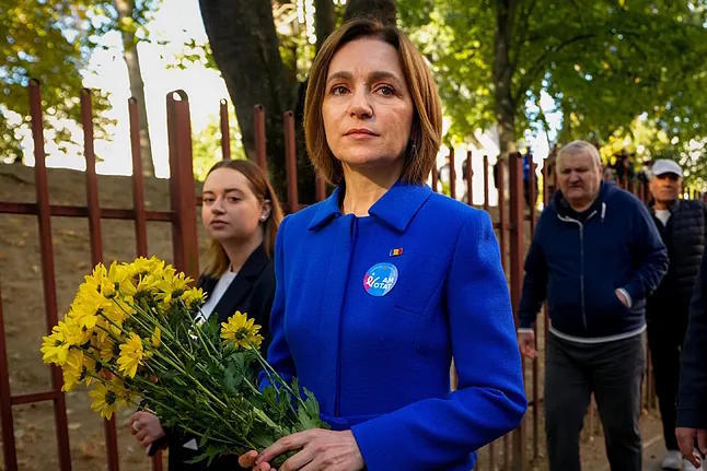 Moldovan President Maia Sandu holds a bouquet of flowers.