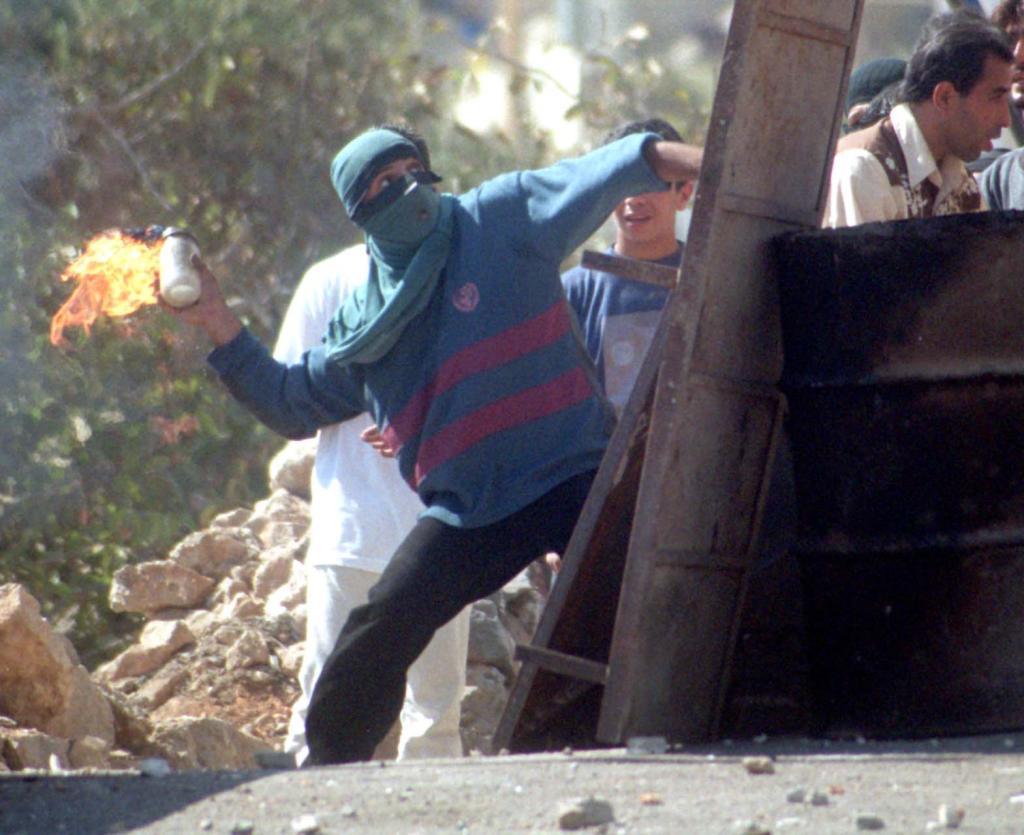 A man throws a Molotov cocktail.