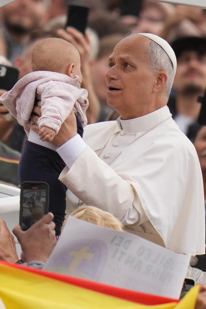 Pope Leo XIV hugs a child.