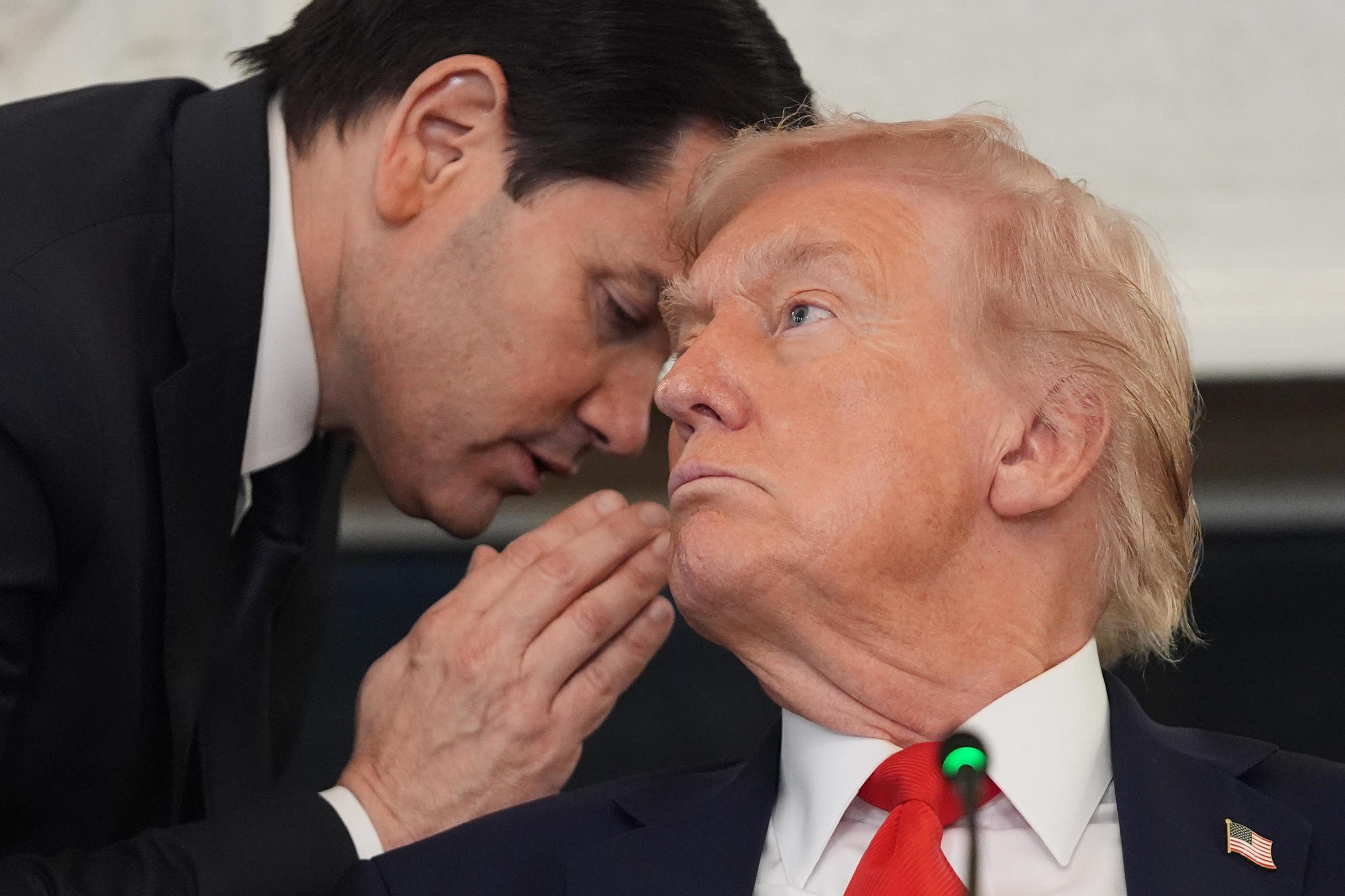 Secretary of State Marco Rubio whispers to President Donald Trump.