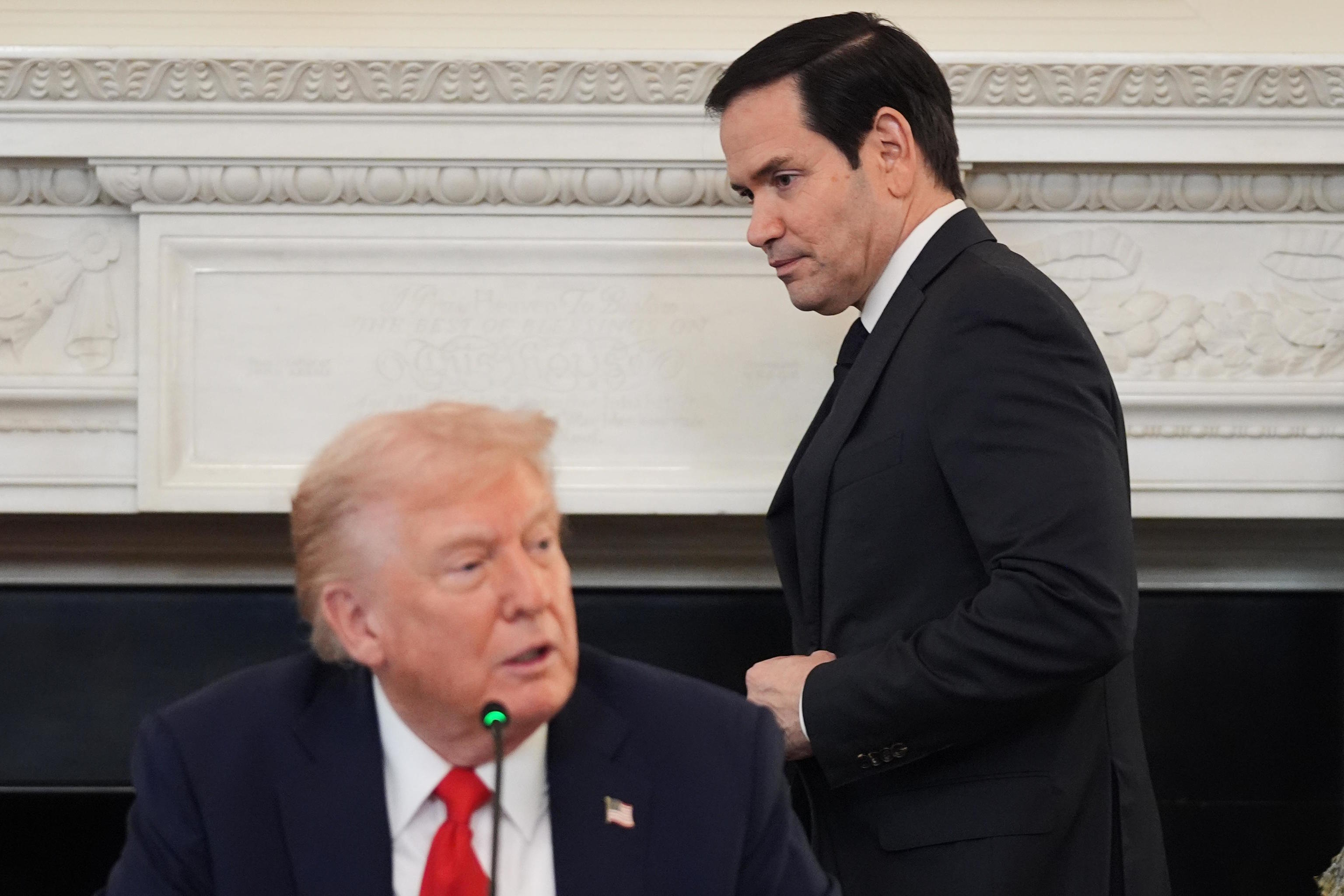 Secretary of State Marco Rubio enters the room behind President Trump.
