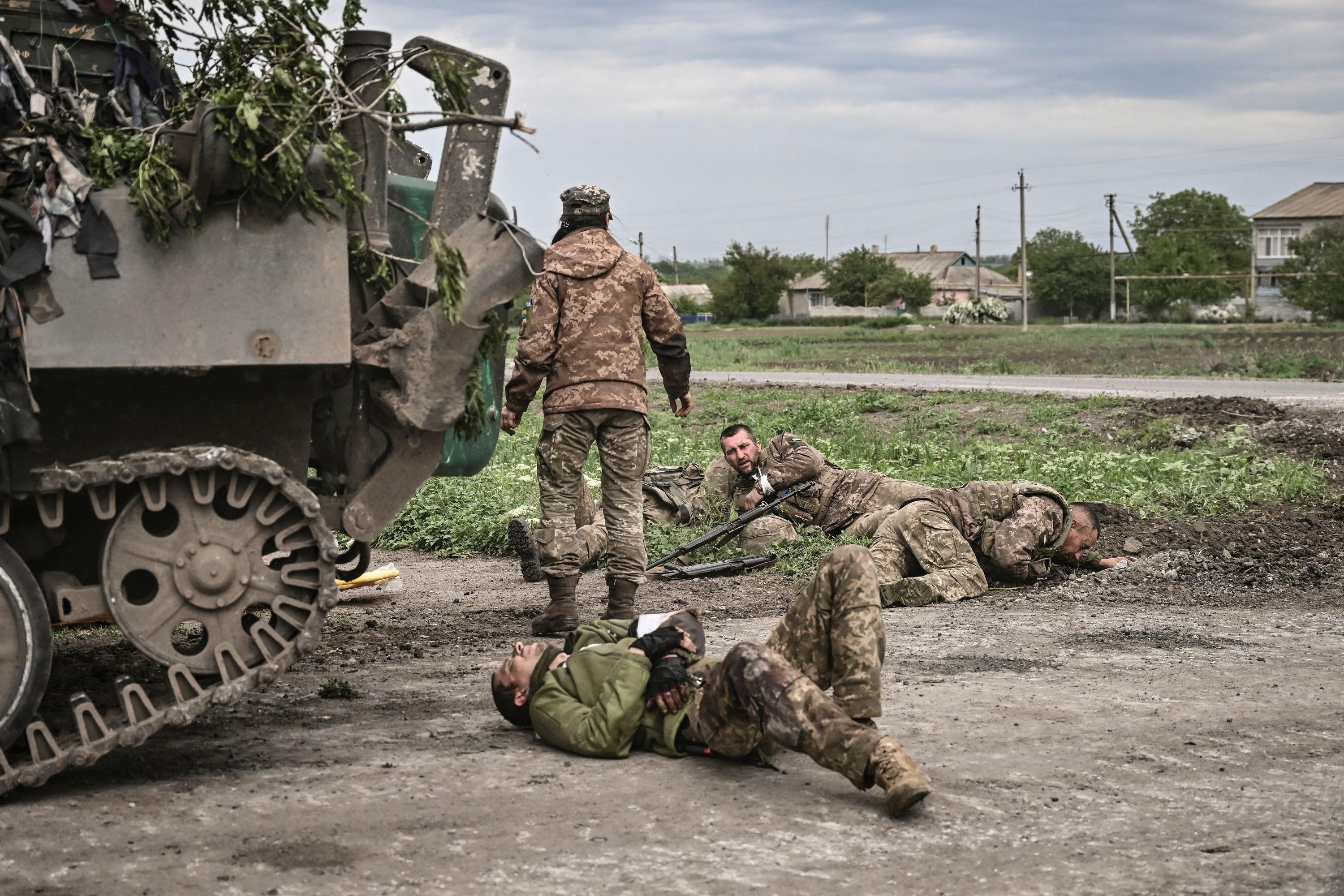 Ukrainian servicemen assist their comrades in the eastern region of Donbas.