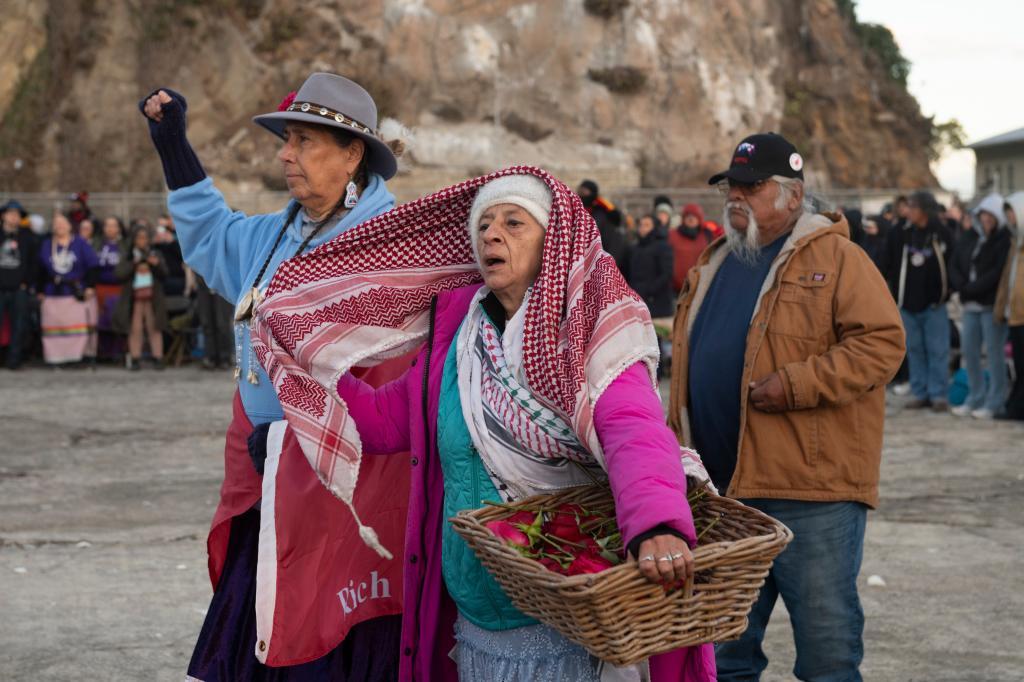 People sing as they attend a sunrise gathering during Indigenous Peoples Day on Alcatraz Island