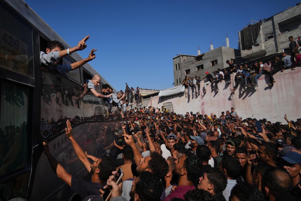 People gather to greet freed Palestinian prisoners arriving on buses in the Gaza Strip