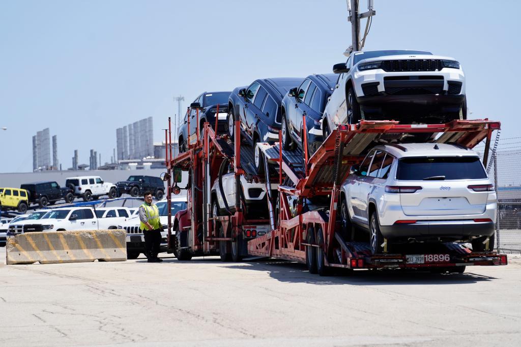 A transport carrying new cars arrives at a Stellantis facility
