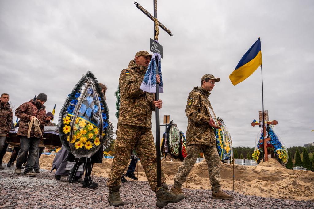 Service members bid farewell during a funeral ceremony to Ukrainian soldier Oleh Pyvovar