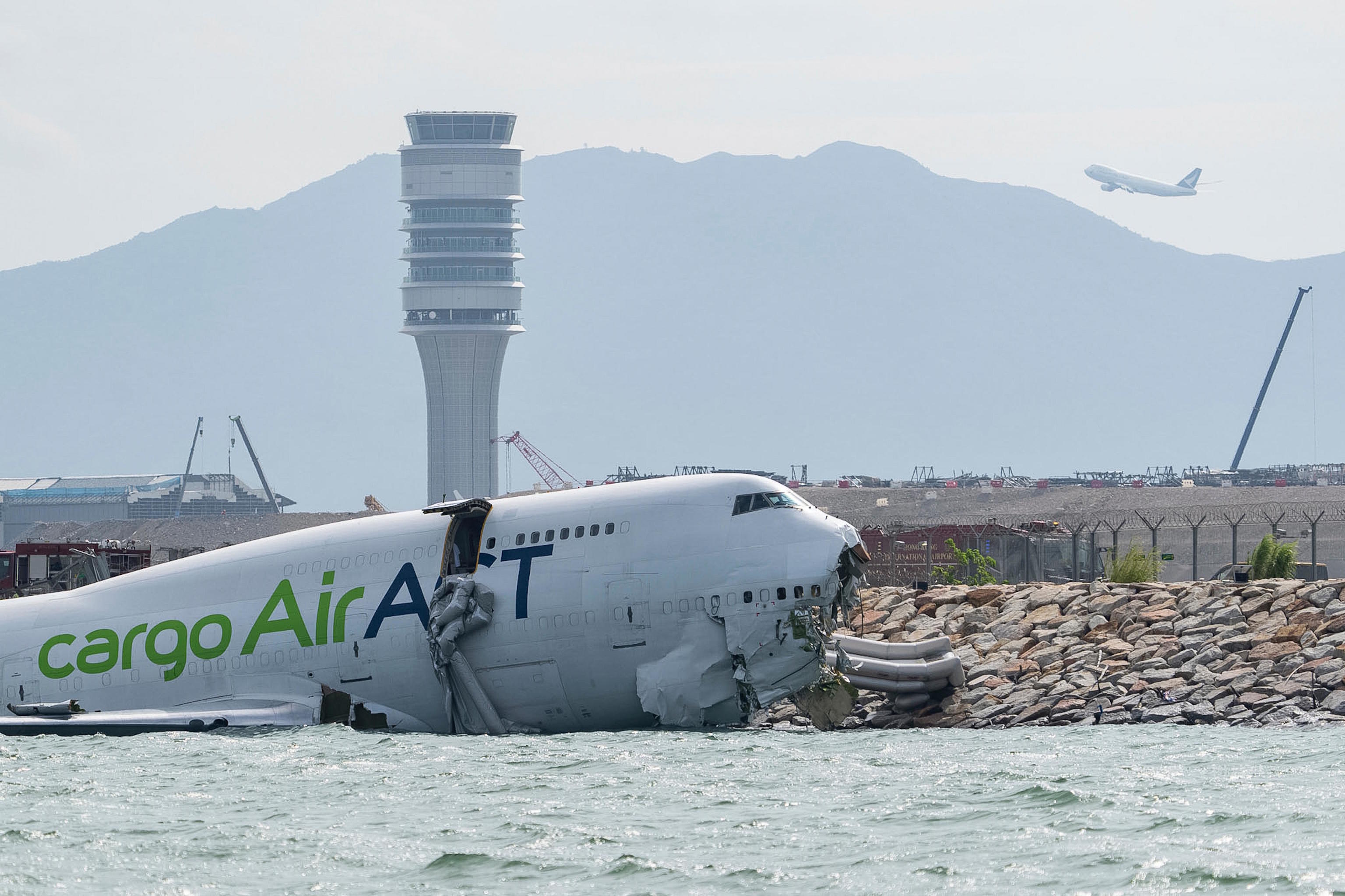 A cargo airplane remains on the water after skidding off the runway.