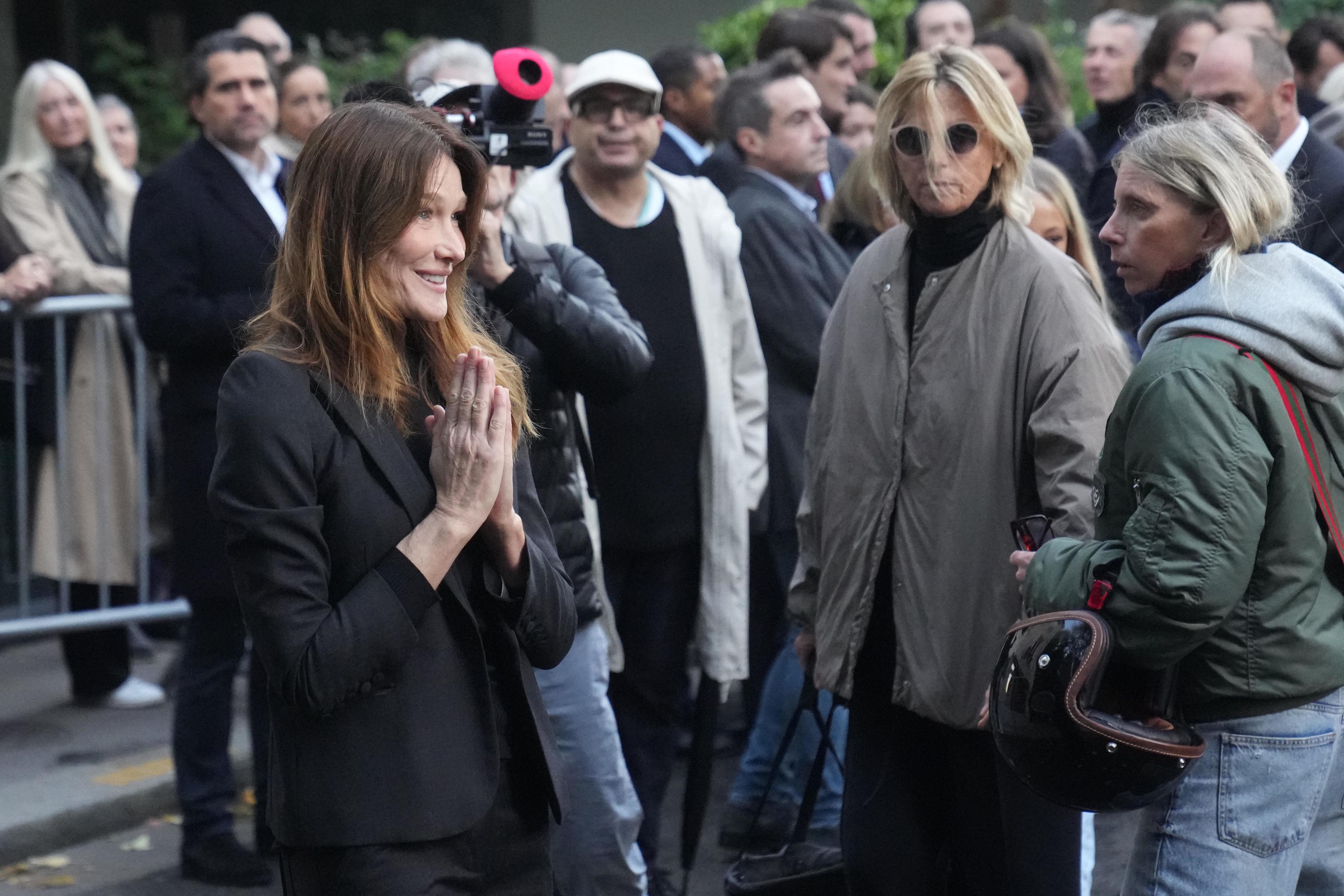 Carla Bruni-Sarkozy gestures as her husband heads to prison.