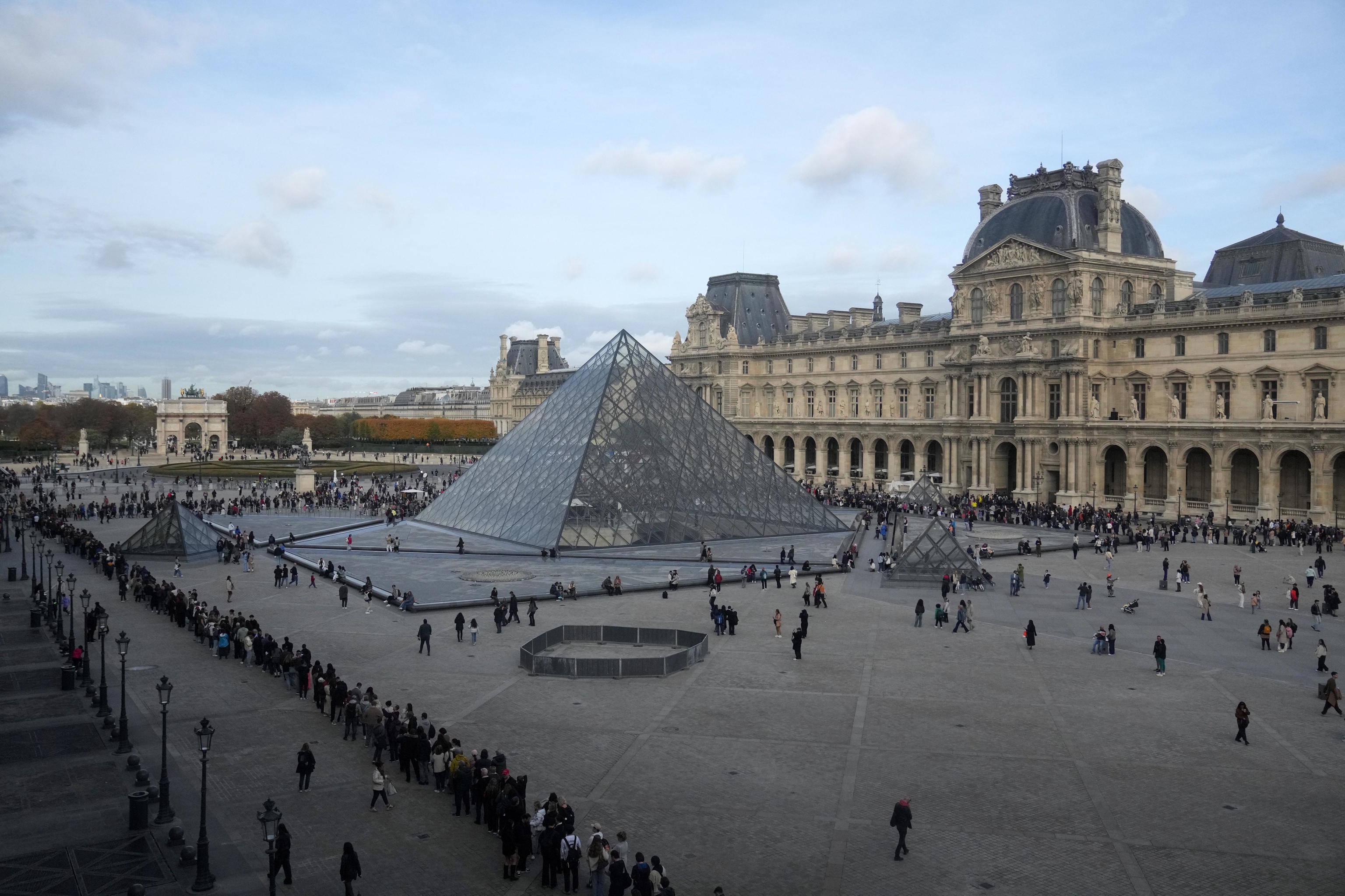 People queue outside the Louvre Museum three days after the historic robbery.