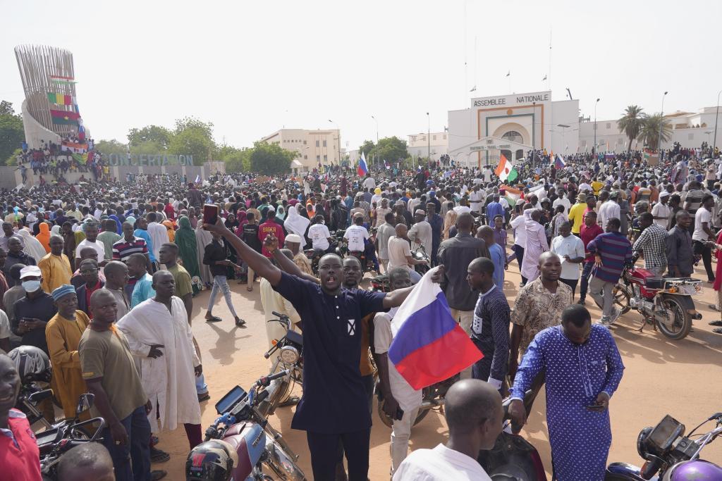 Nigeriens, some holding Russian flags, participate in a march called by supporters of coup leader Gen. Abdourahmane Tchiani