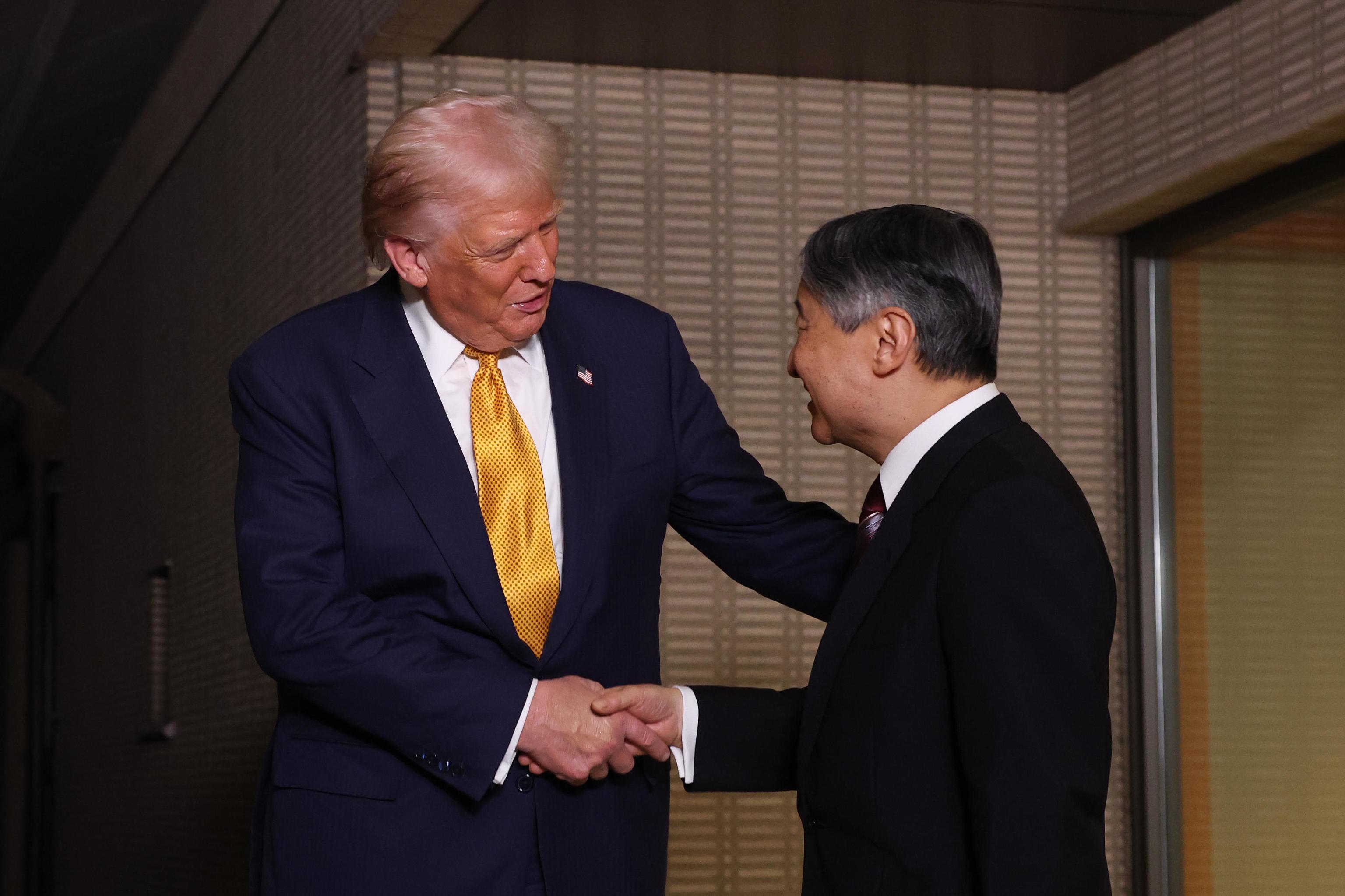 President Donald Trump, left, and Japan's Emperor Naruhito shake hands.