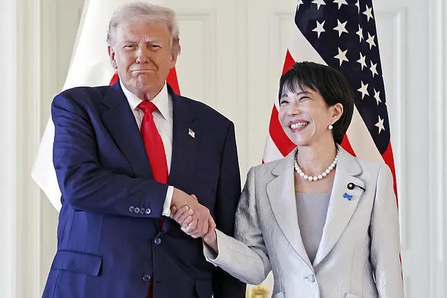 Donald Trump shakes hands with Prime Minister Sanae Takaichi.