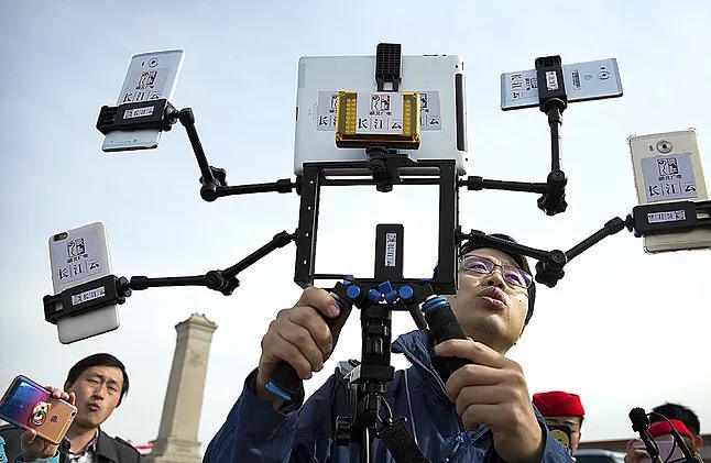 A man records and streams a meeting of the Chinese Government held in Beijing on March 11.
