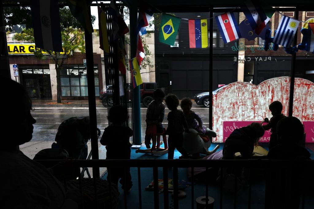 A nanny keeps watch as children play in the window at Luna y Cielo Play Cafe