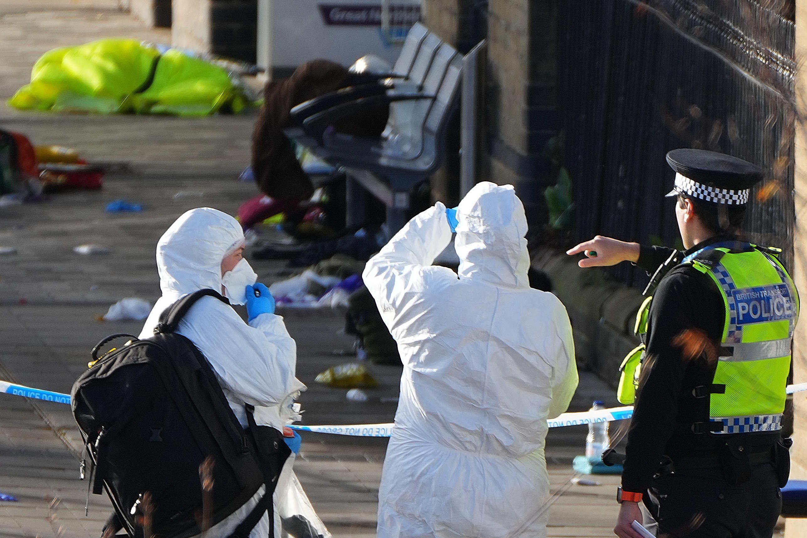 Forensic investigators look at the area after a mass stabbing on train in London.