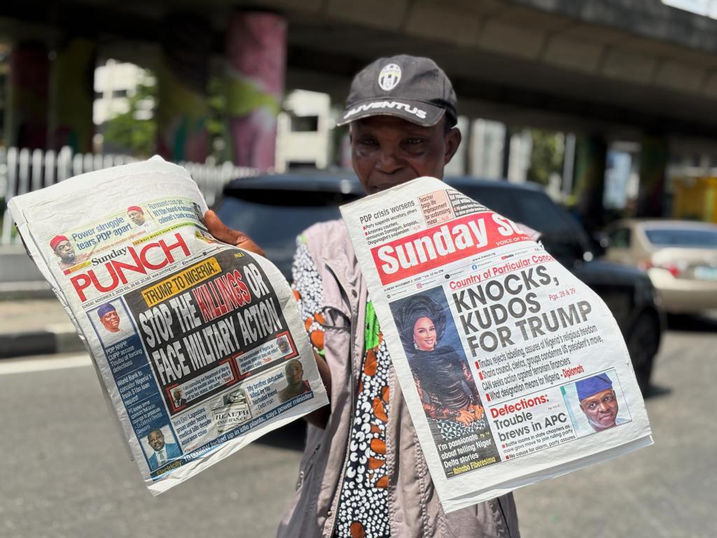 A vendor sells local newspapers with headlines referring to US President Donald Trump's comments about Nigeria,