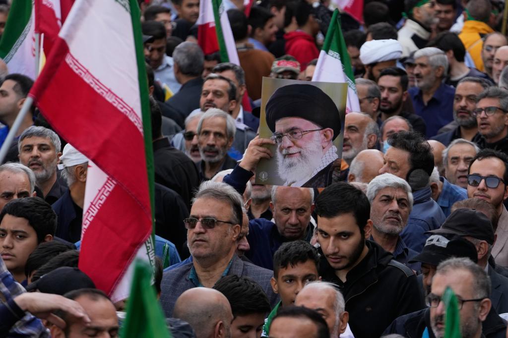 A demonstrator holds up a poster of the Iranian Supreme Leader Ayatollah Ali Khamenei