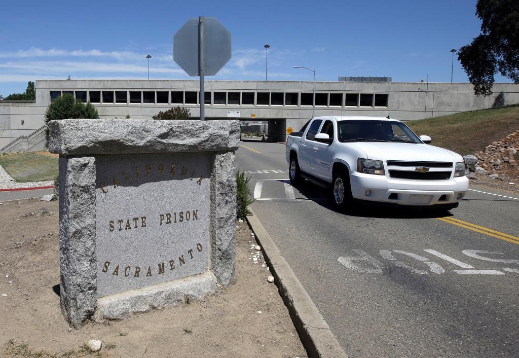 A vehicle drives by the main entrance to California State Prison