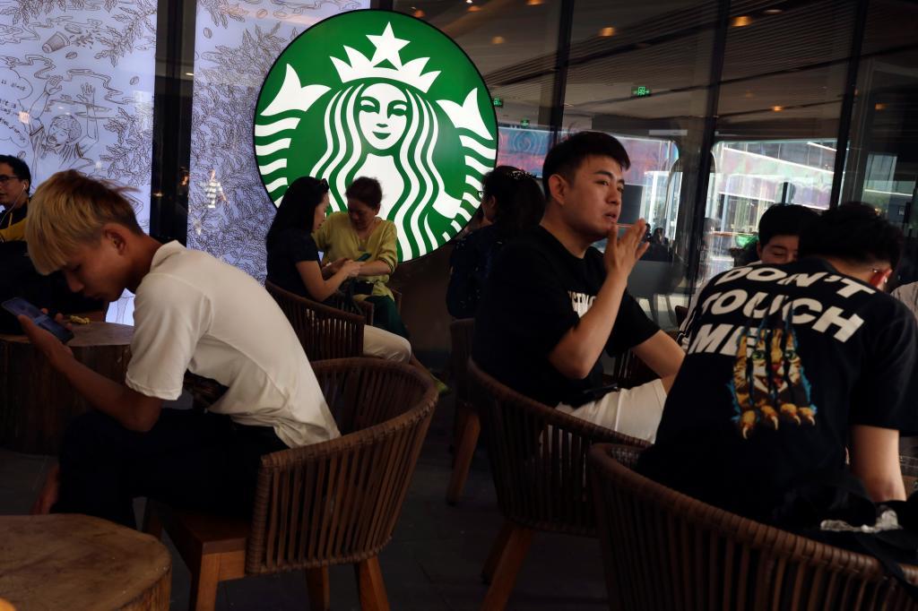 Chinese customers enjoy their drinks at a store of U.S. coffee giant Starbucks in Beijing