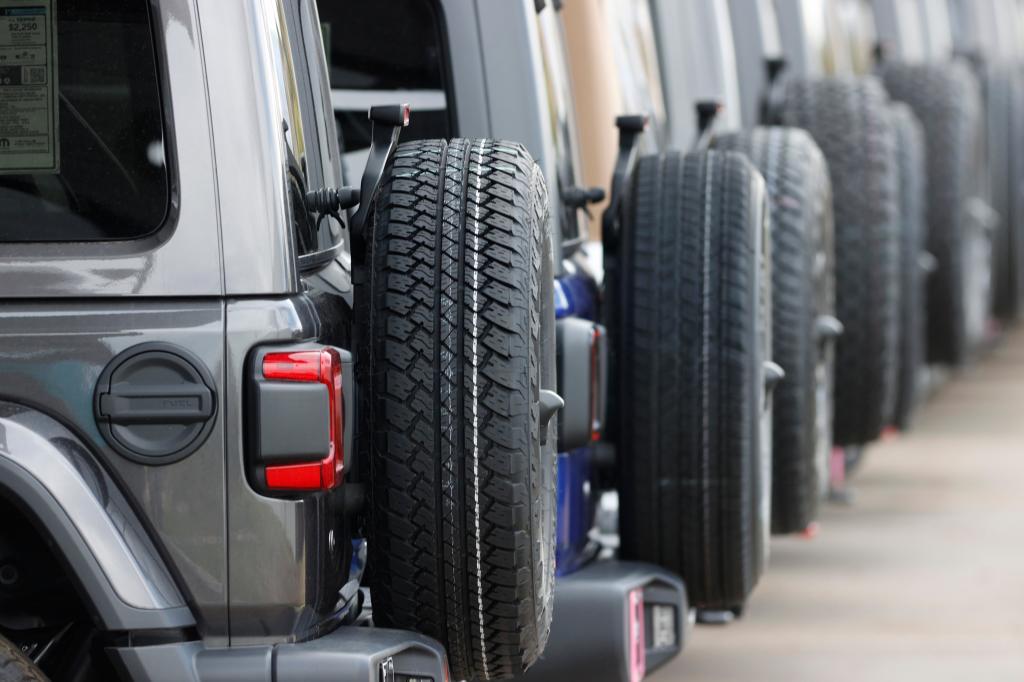 Spare tires are seen on a long row of unsold 2020 Wranglers sit at a Jeep dealership in Englewood