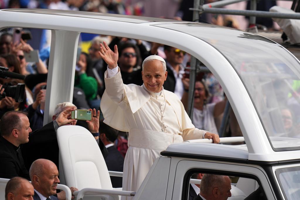 Pope Leo XIV waves from his popemobile.