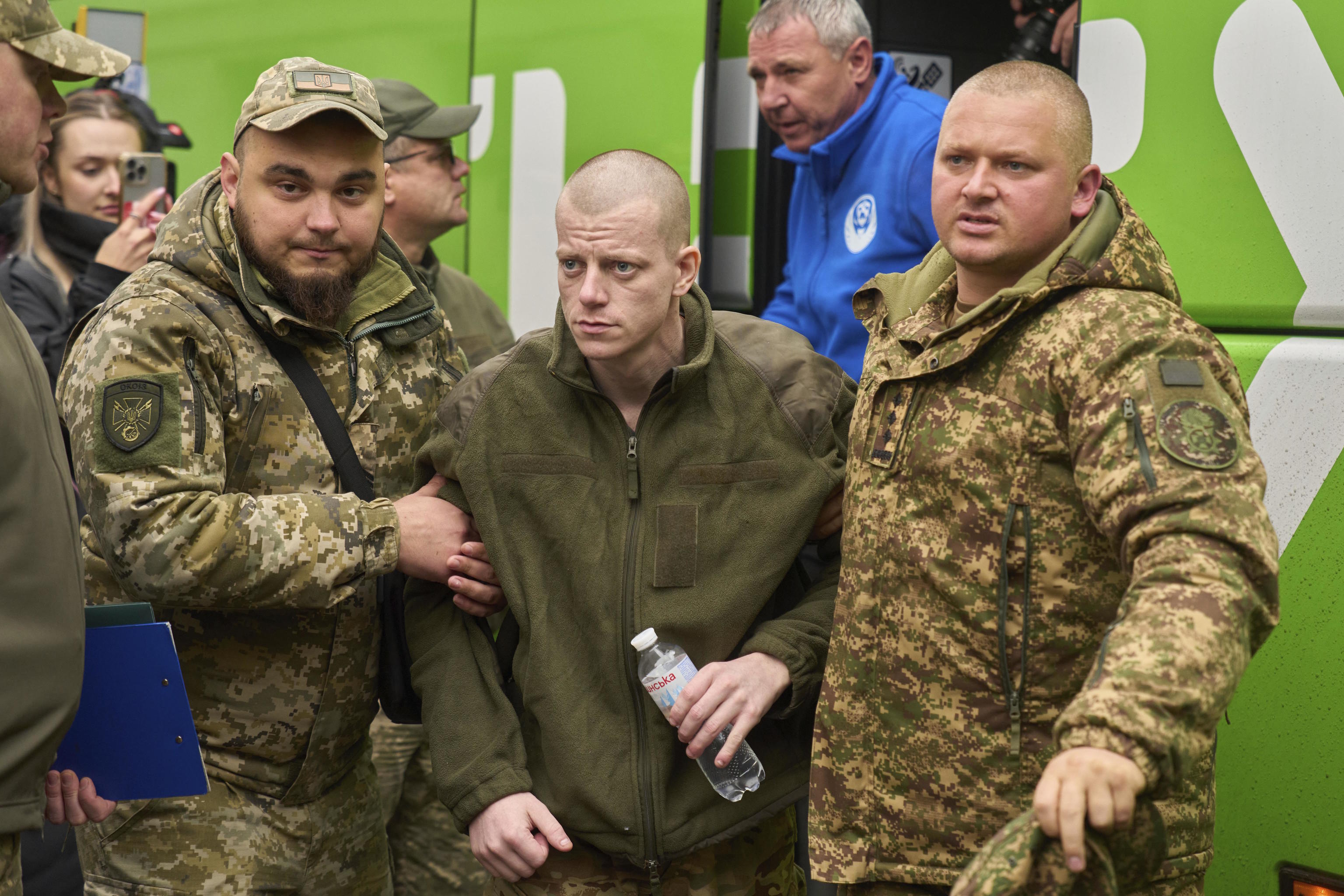 Servicemen help a soldier returning from Russian captivity.