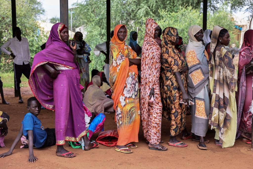 Women wait for cash assistance and dry grain from the U.N. World Food Program in Gendrassa refugee camp, Maban