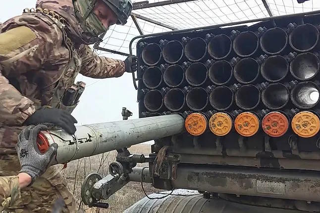 Russian soldiers load a multiple rocket launcher.