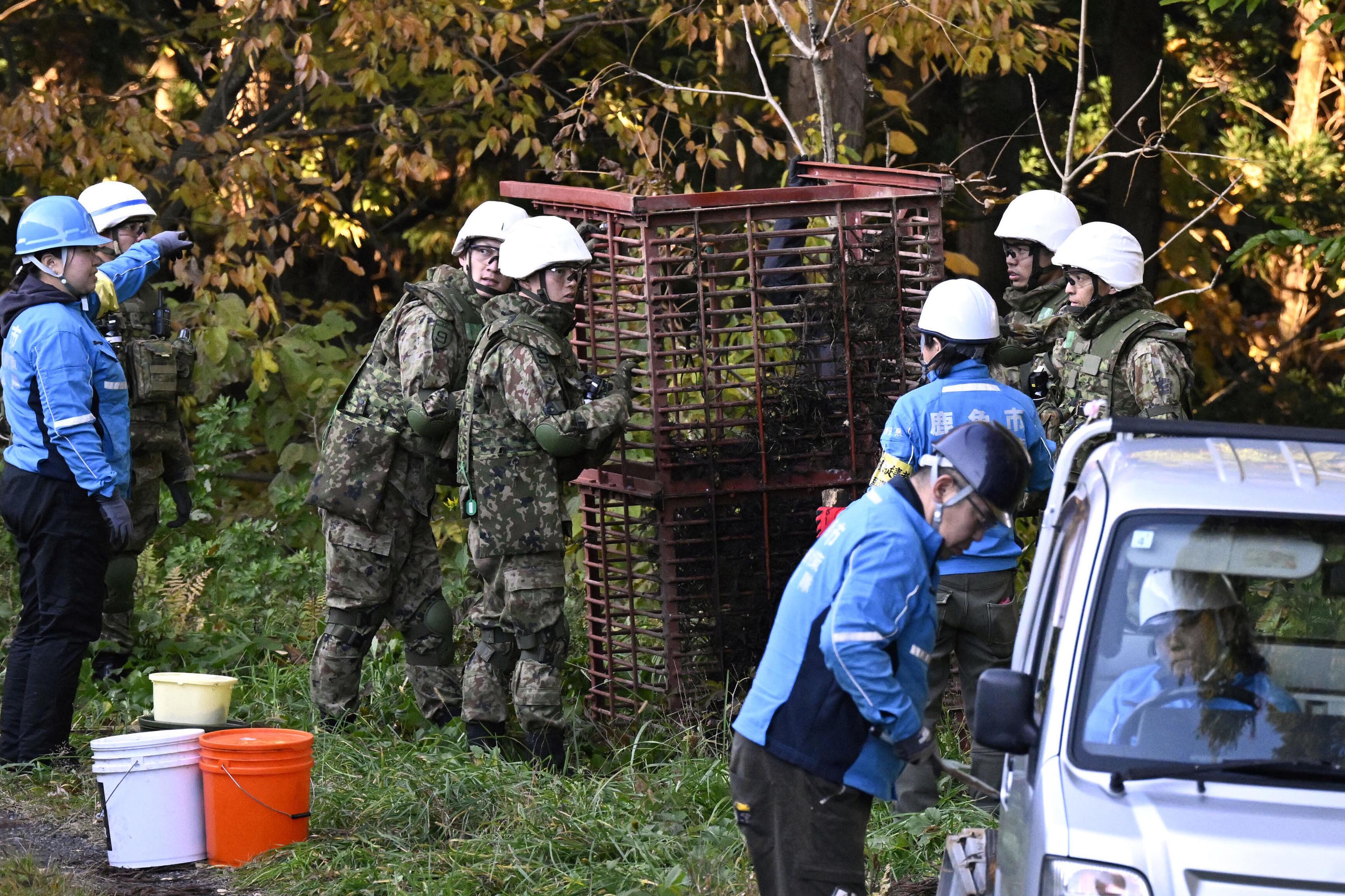 Japan Ground Self-Defense Force members set up a box trap to capture bears.