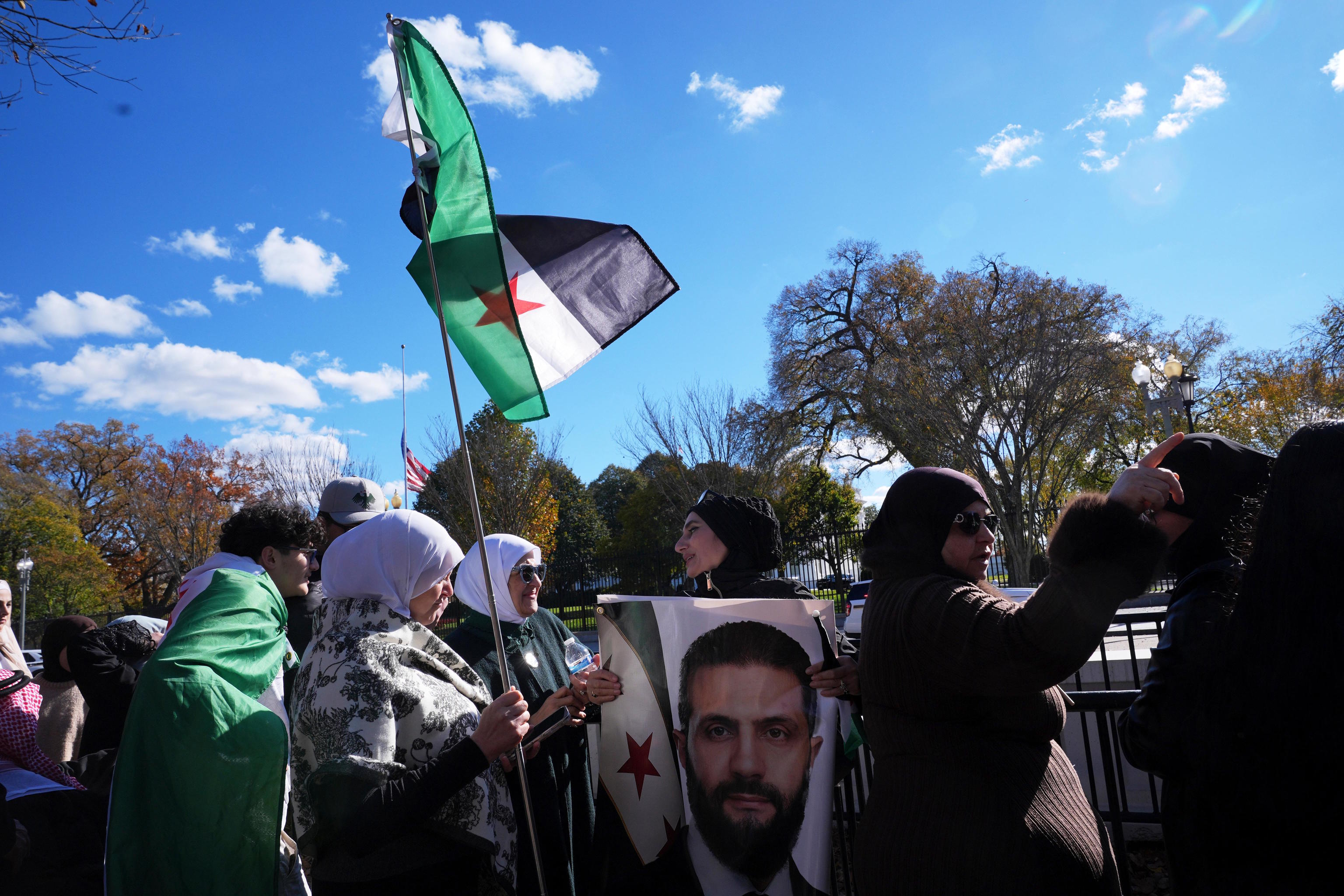 People wave a Syrian flag during a visit by Syria's President.