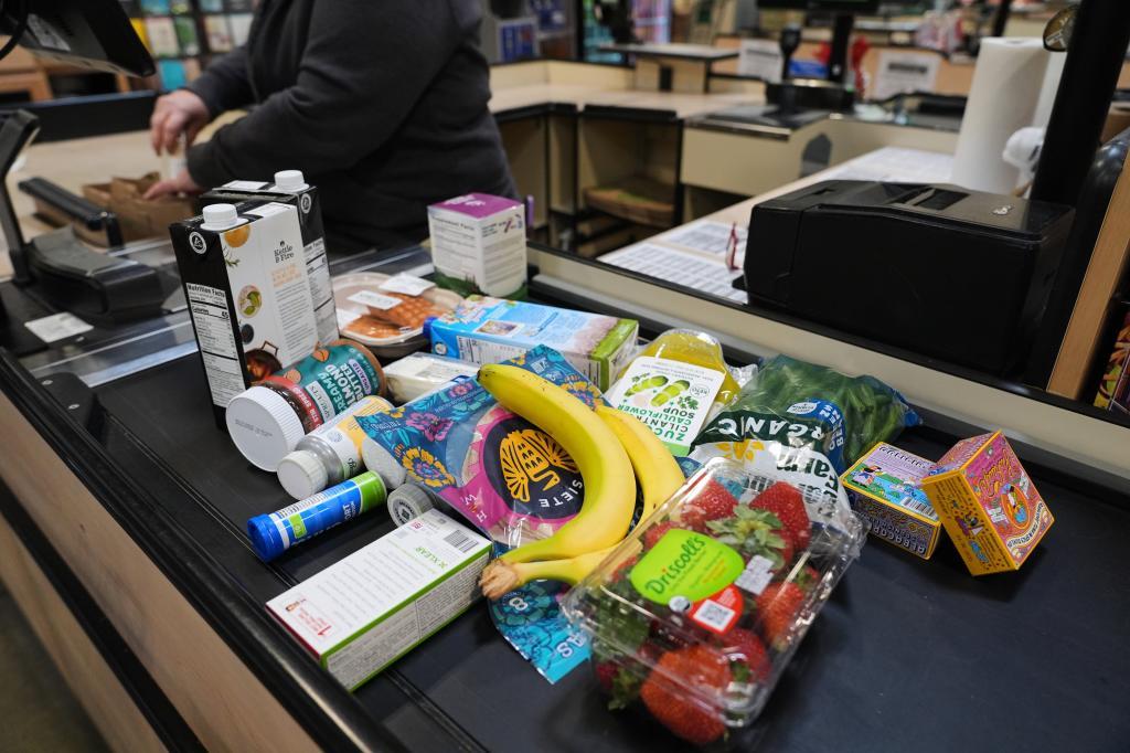 A cashier scans groceries, including produce