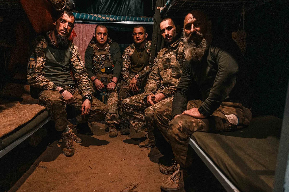 Five Ukrainian artillery crew members inside their shelter.