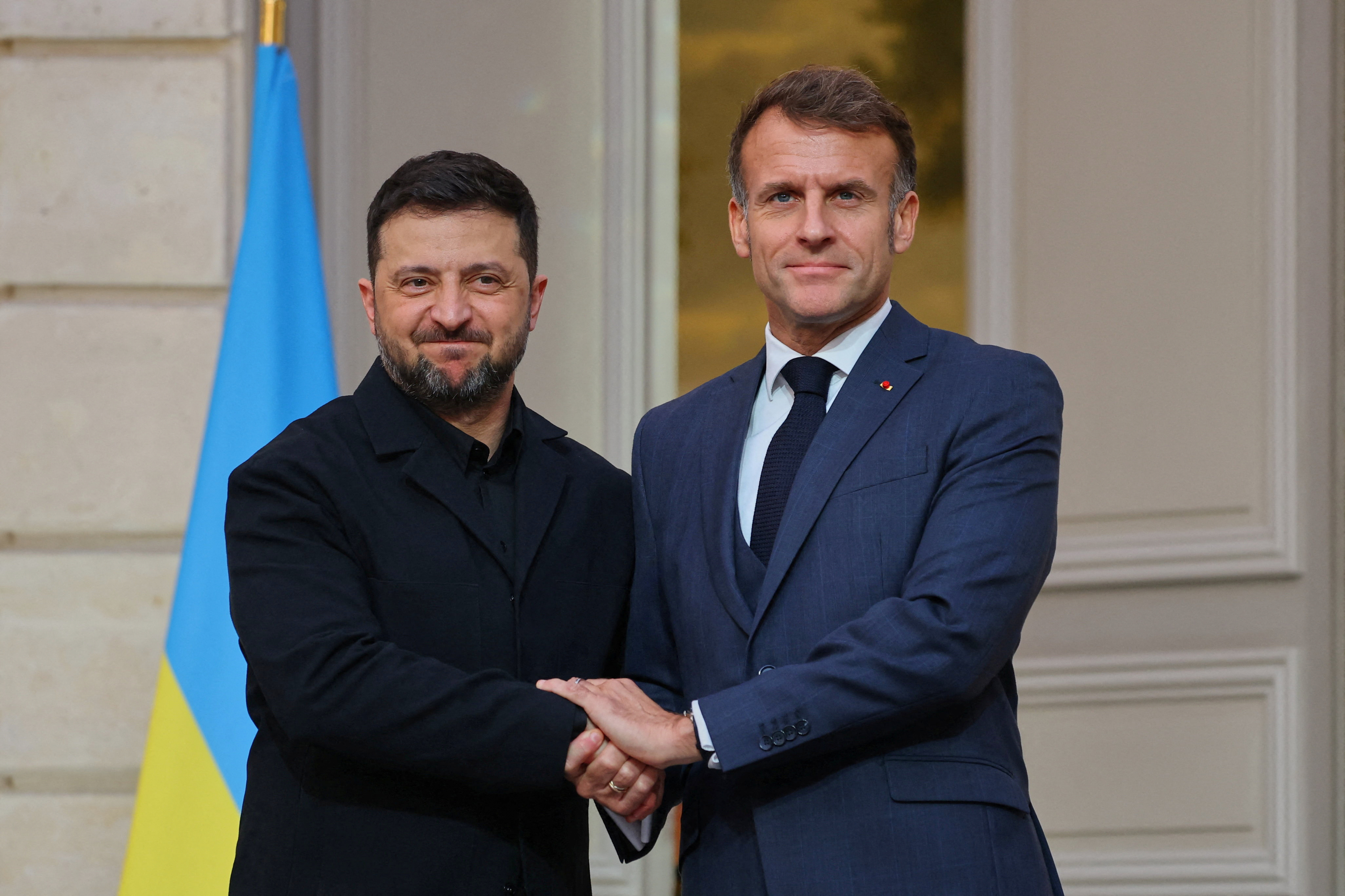 Ukrainian President Volodymyr Zelenskyy, left, and French President Emmanuel Macron shake hands.