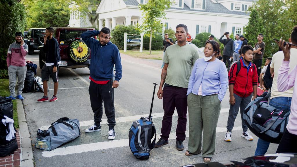 Immigrants gather with their belongings outside St. Andrews Episcopal Church