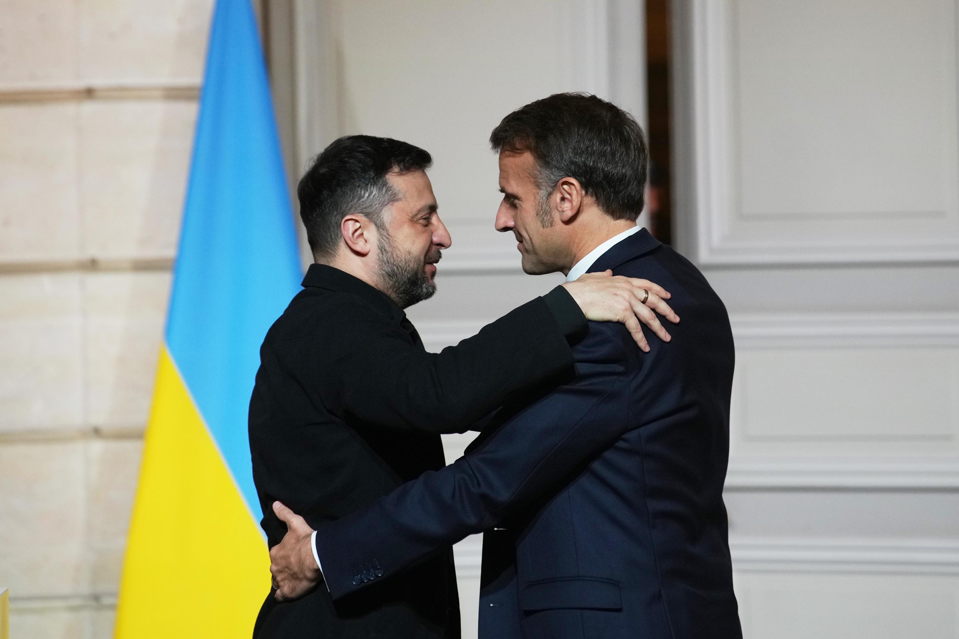 Emmanuel Macron embraces Volodimir Zelenskyy.