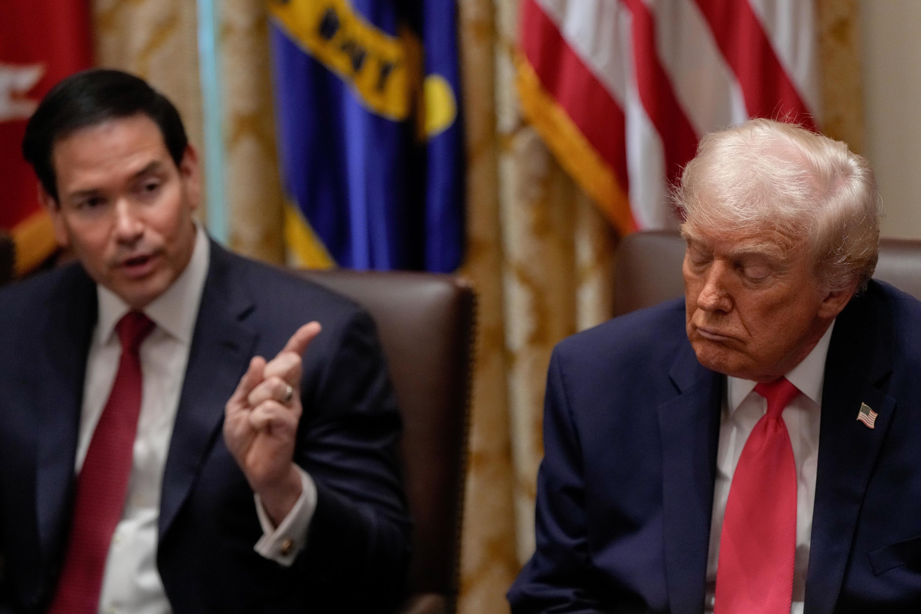 President Trump closes his eyes as Marco Rubio speaks during a Cabinet meeting.