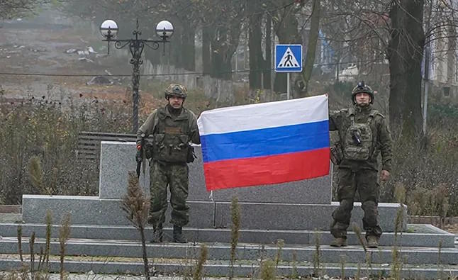Russian soldiers display a flag of the Federation.