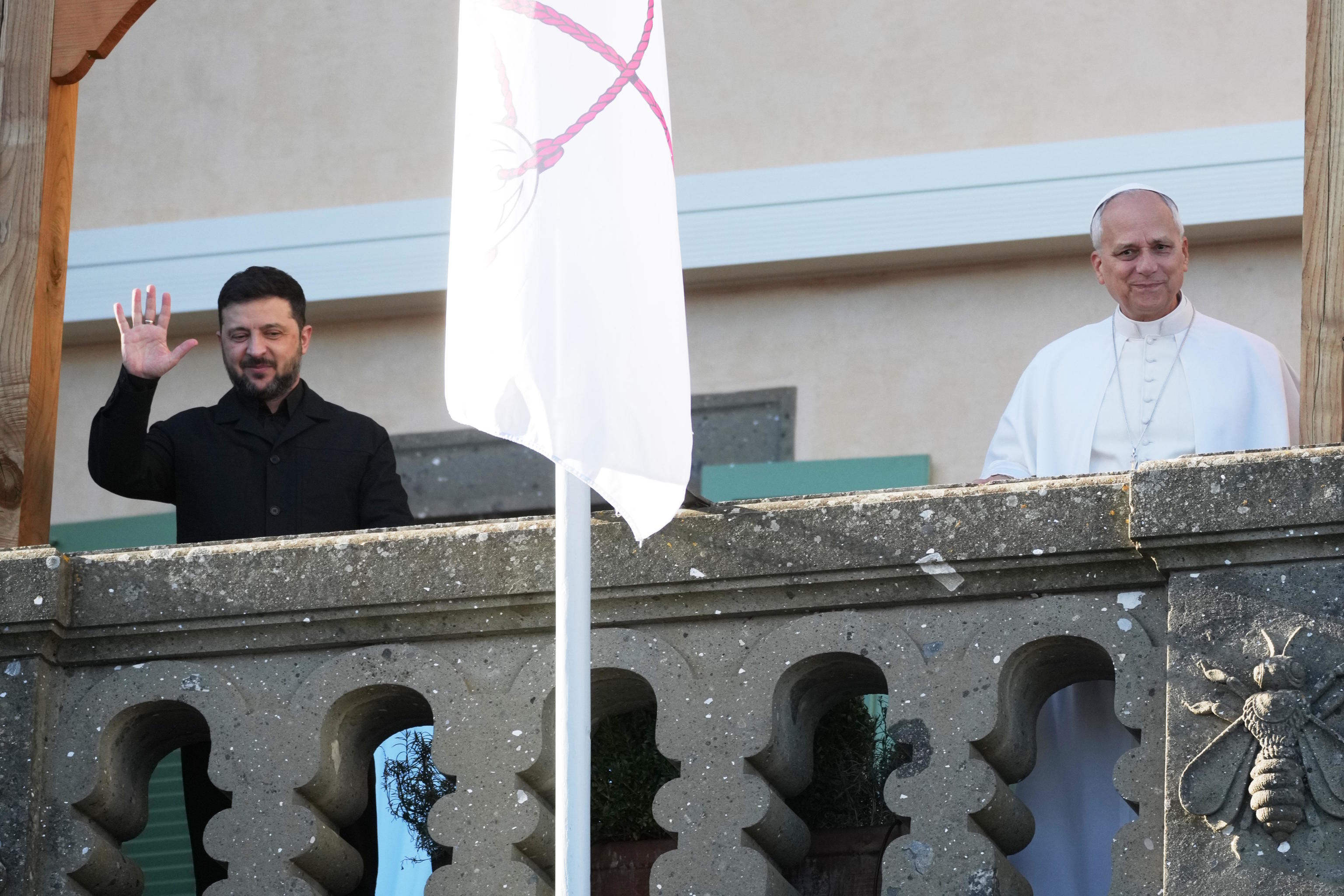 Zelenskyy and Pope Leo XIV wave to journalists during their meeting.