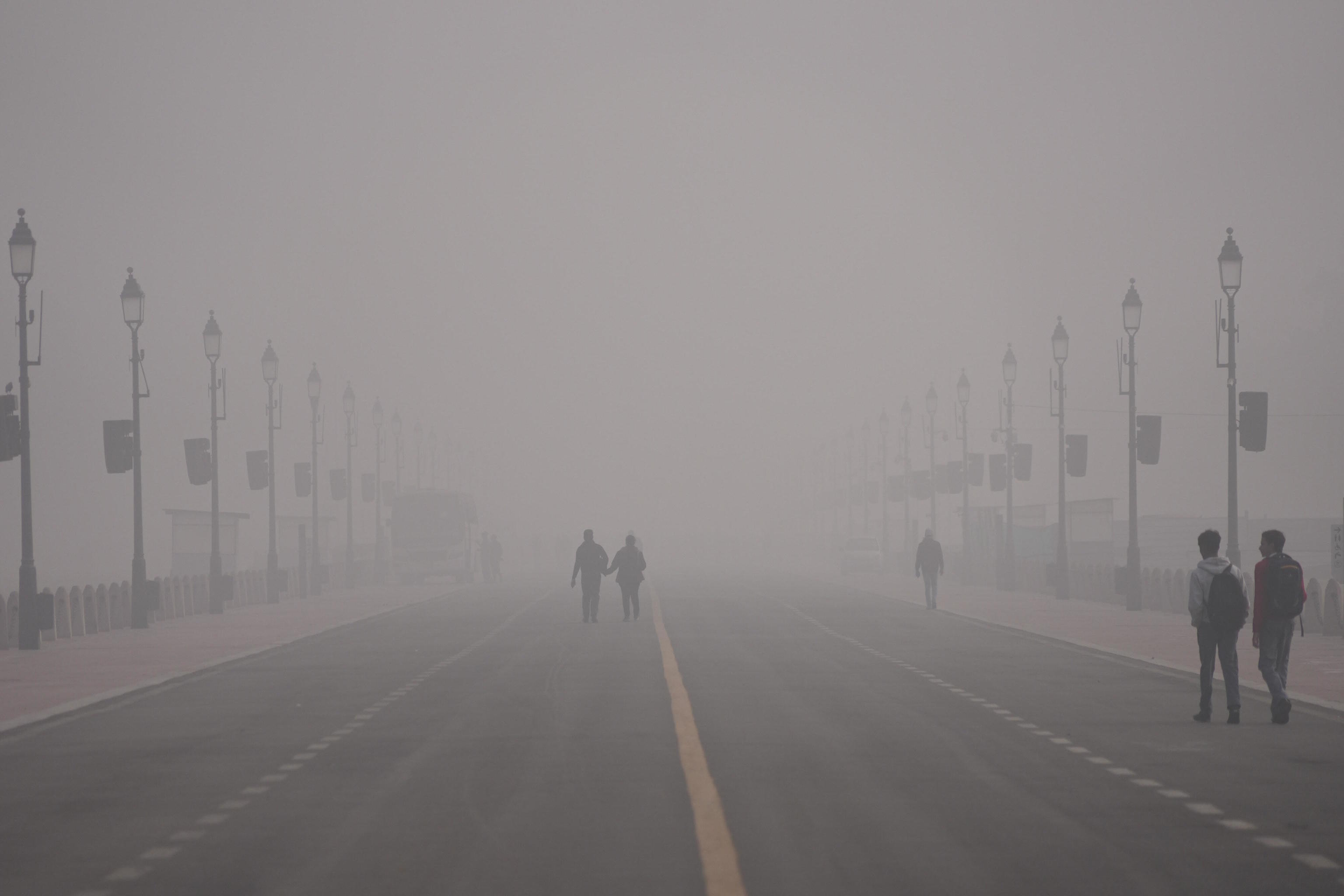 People walk in the morning on a smog-filled morning in New Delhi.