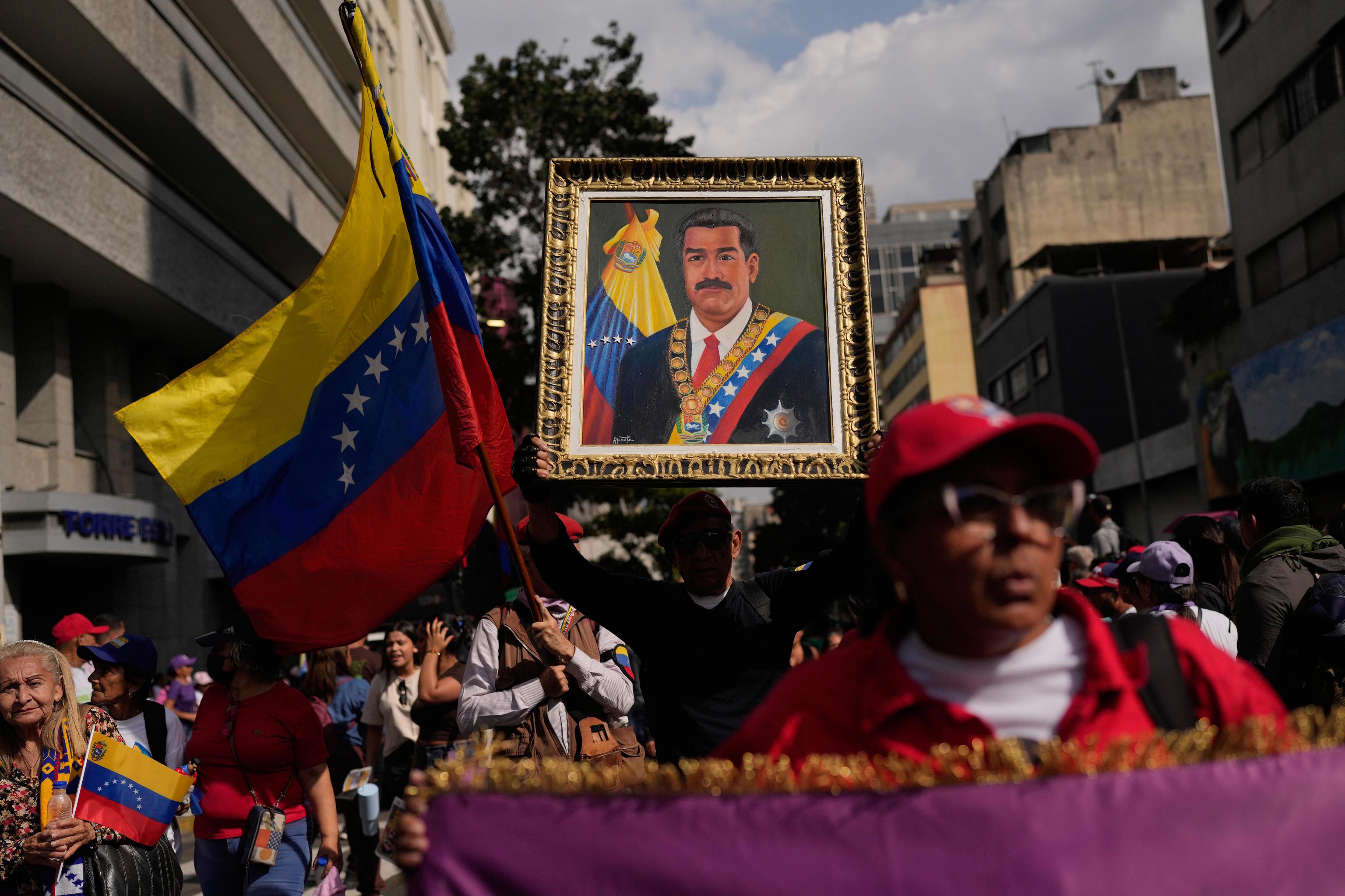 A government supporter holds an image of President Nicolas Maduro.