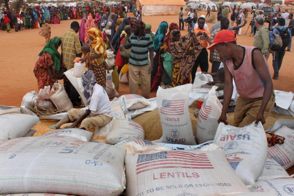 Workers distribute food aid from the World Food Program at a refugee camp in Dolo, Somalia