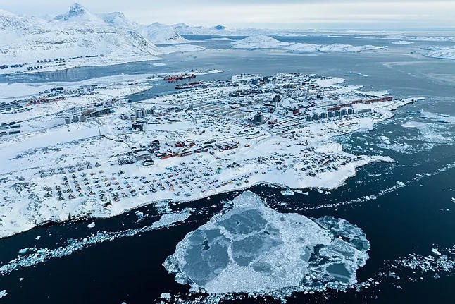 Snow-covered houses on the coast of a sea inlet in Nuuk (Greenland).