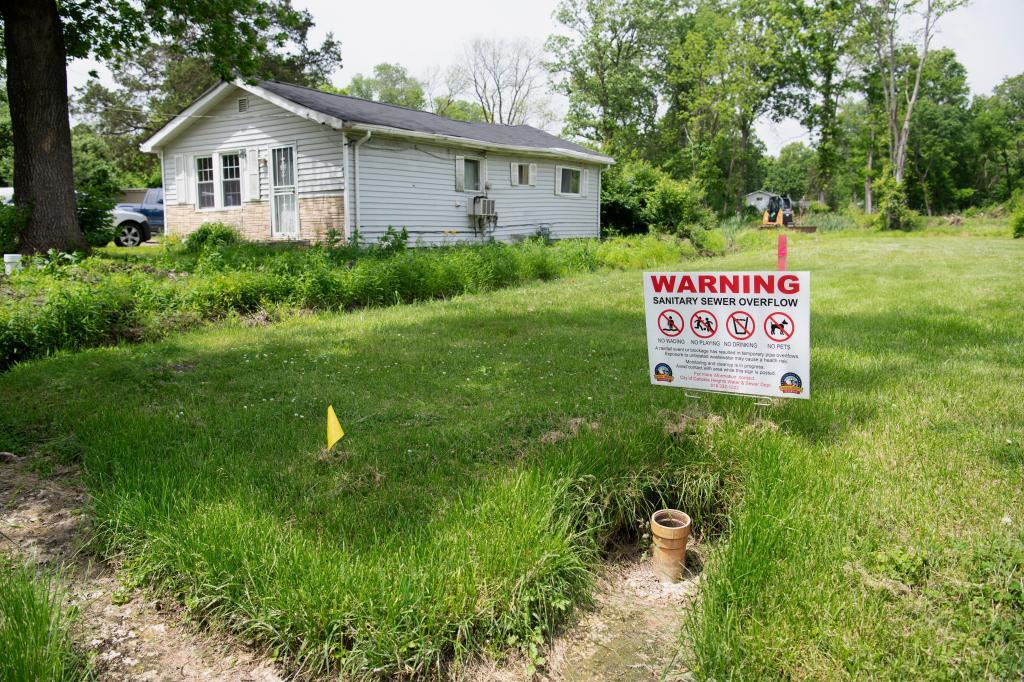 A sign warns of the dangers of sewer overflows in flood-prone Cahokia Heights