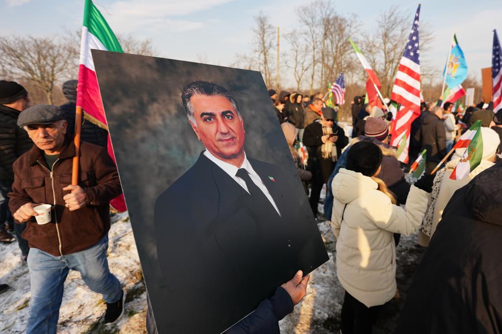 A member of the Iranian community holds a photograph of Iran's exiled crown prince Reza Pahlavi