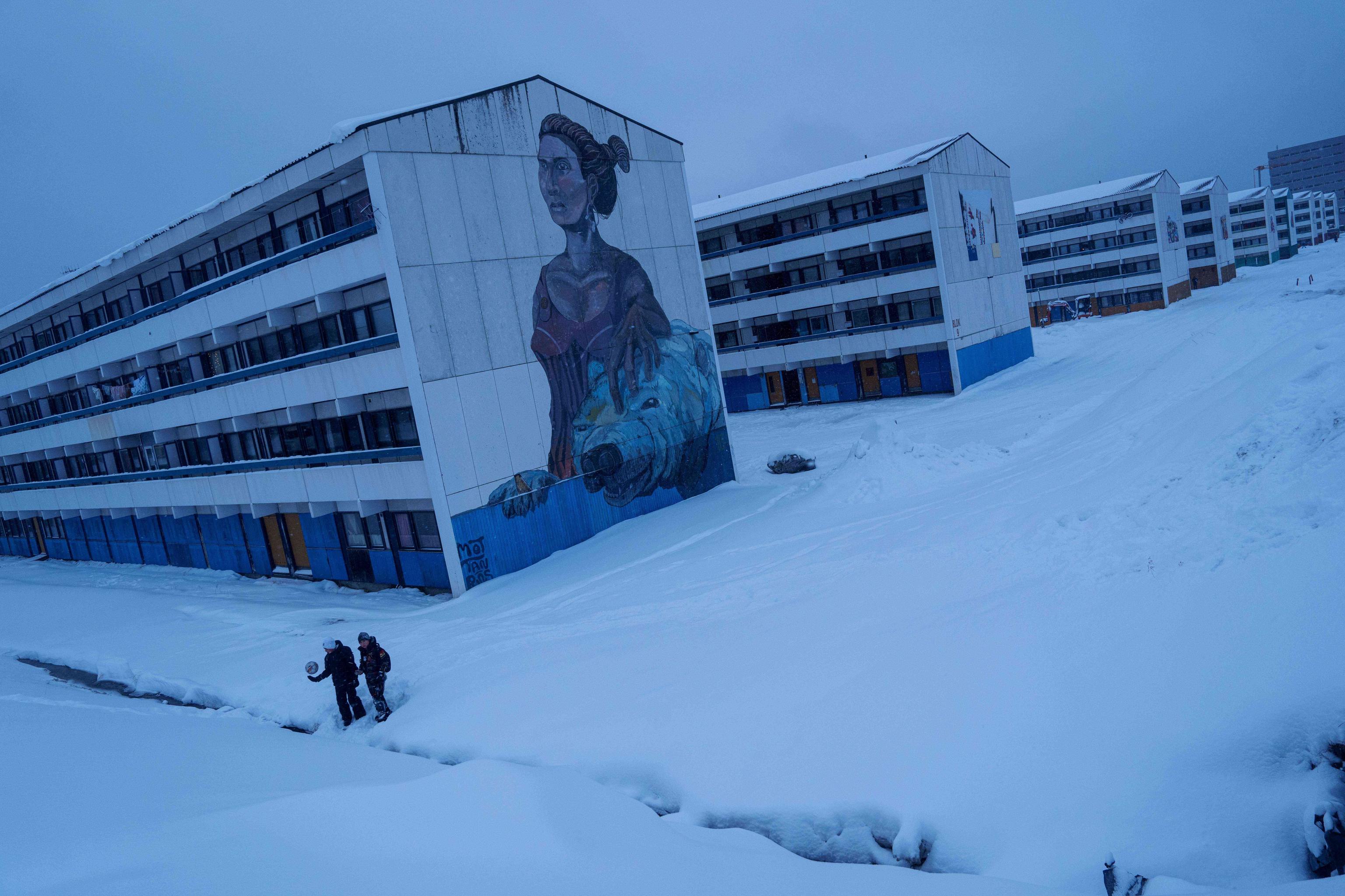 Youths play with a ball in the snow.