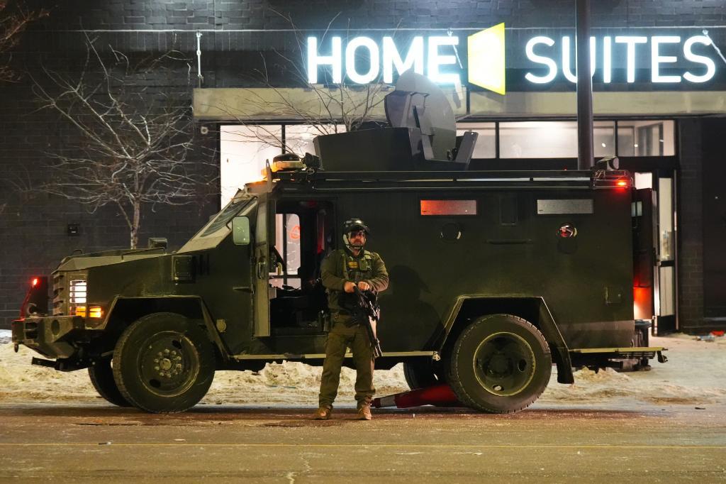 A federal agent stands guard near a hotel.