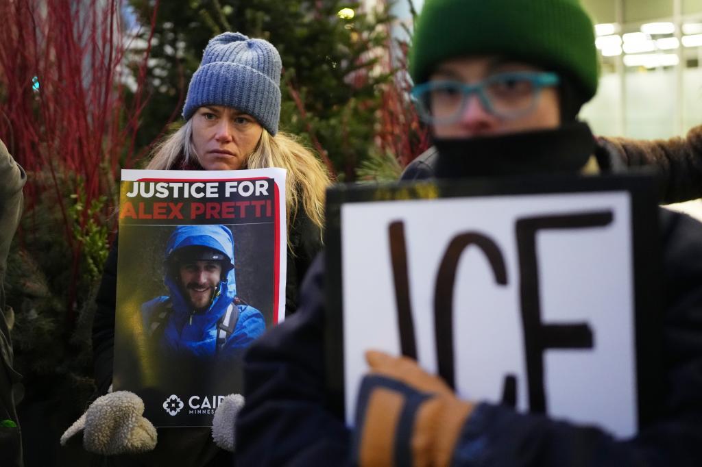 Demonstrator holds signs during a protest outside the office of Sen. Amy Klobuchar