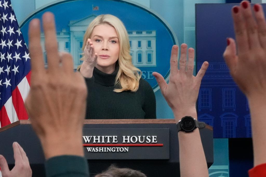 Reporters raise their hands to ask a question as White House press secretary Karoline Leavitt