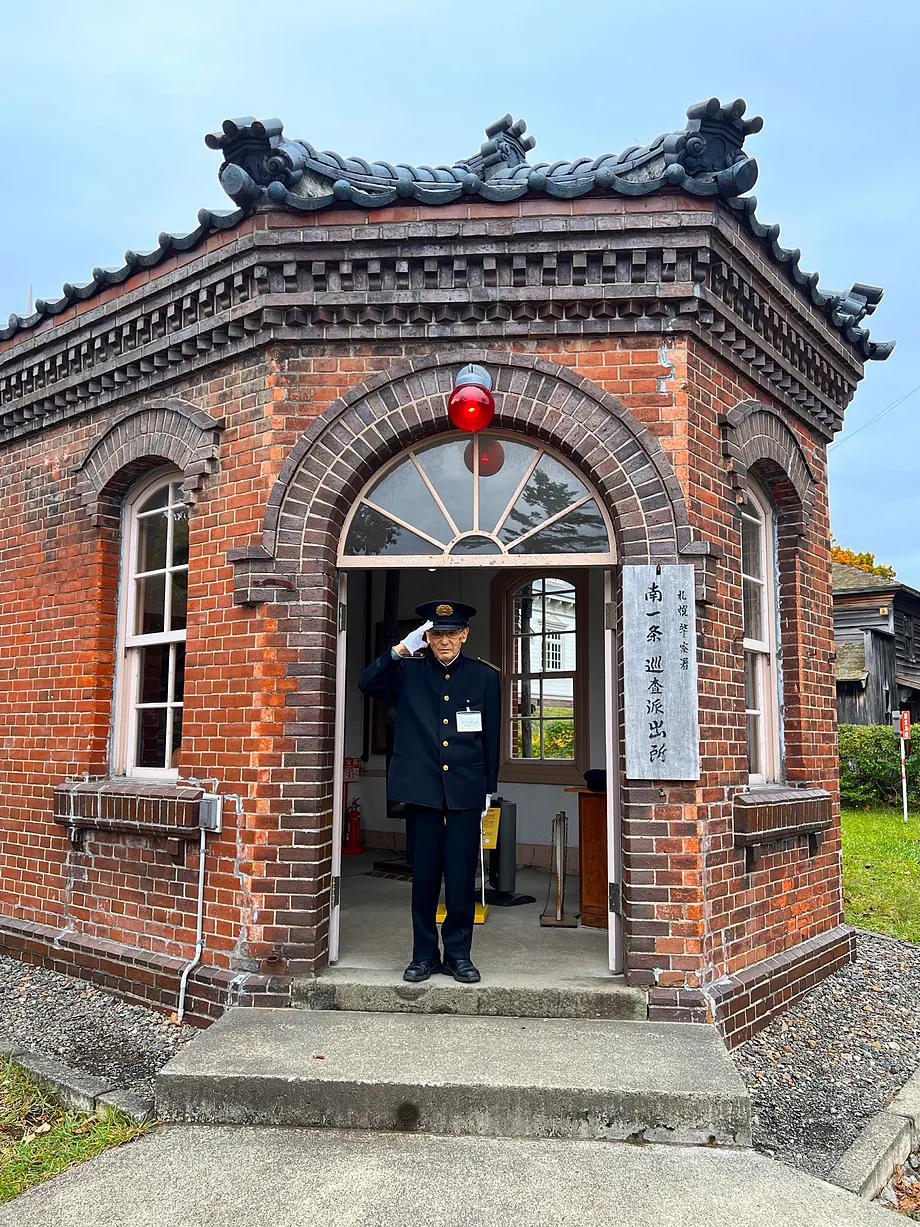 Man dressed as a postman greets at the Historical Village of Hokkaido, an open-air museum showing life on the island in the late 19th century.