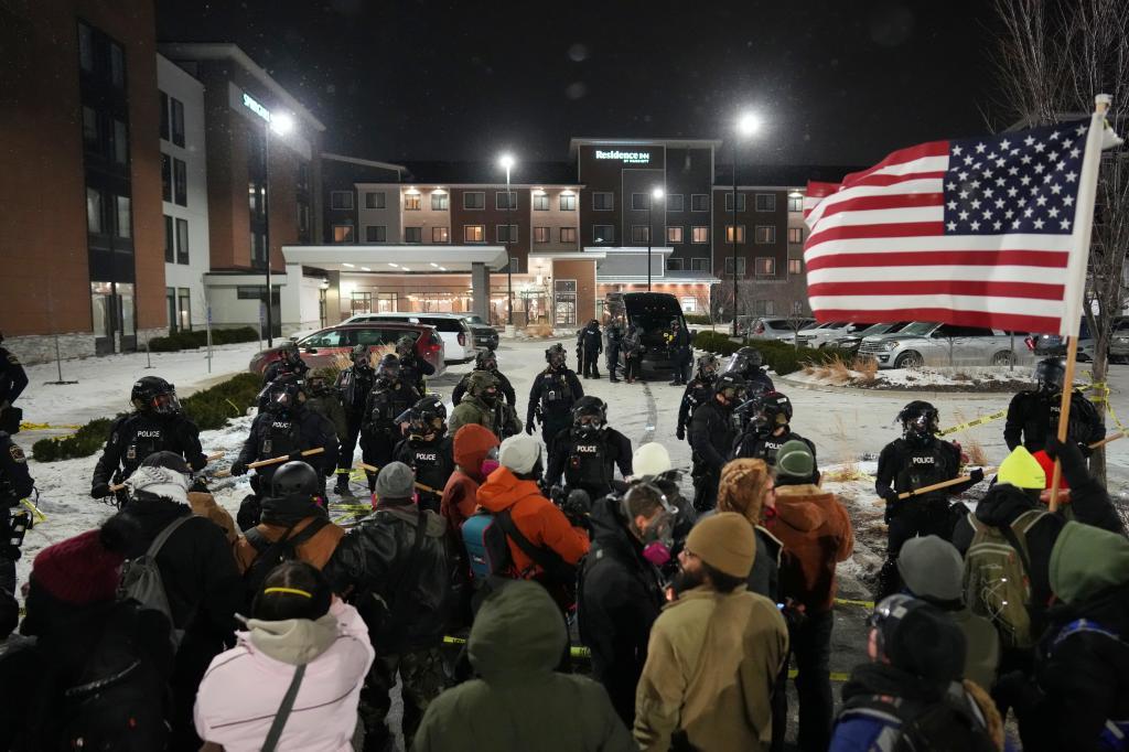 Demonstrators stand against law enforcement officers during a protest